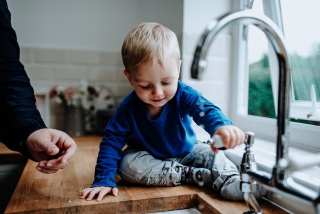 Boy playing with water taps at a Cheshire Lifestyle Family Photography Session