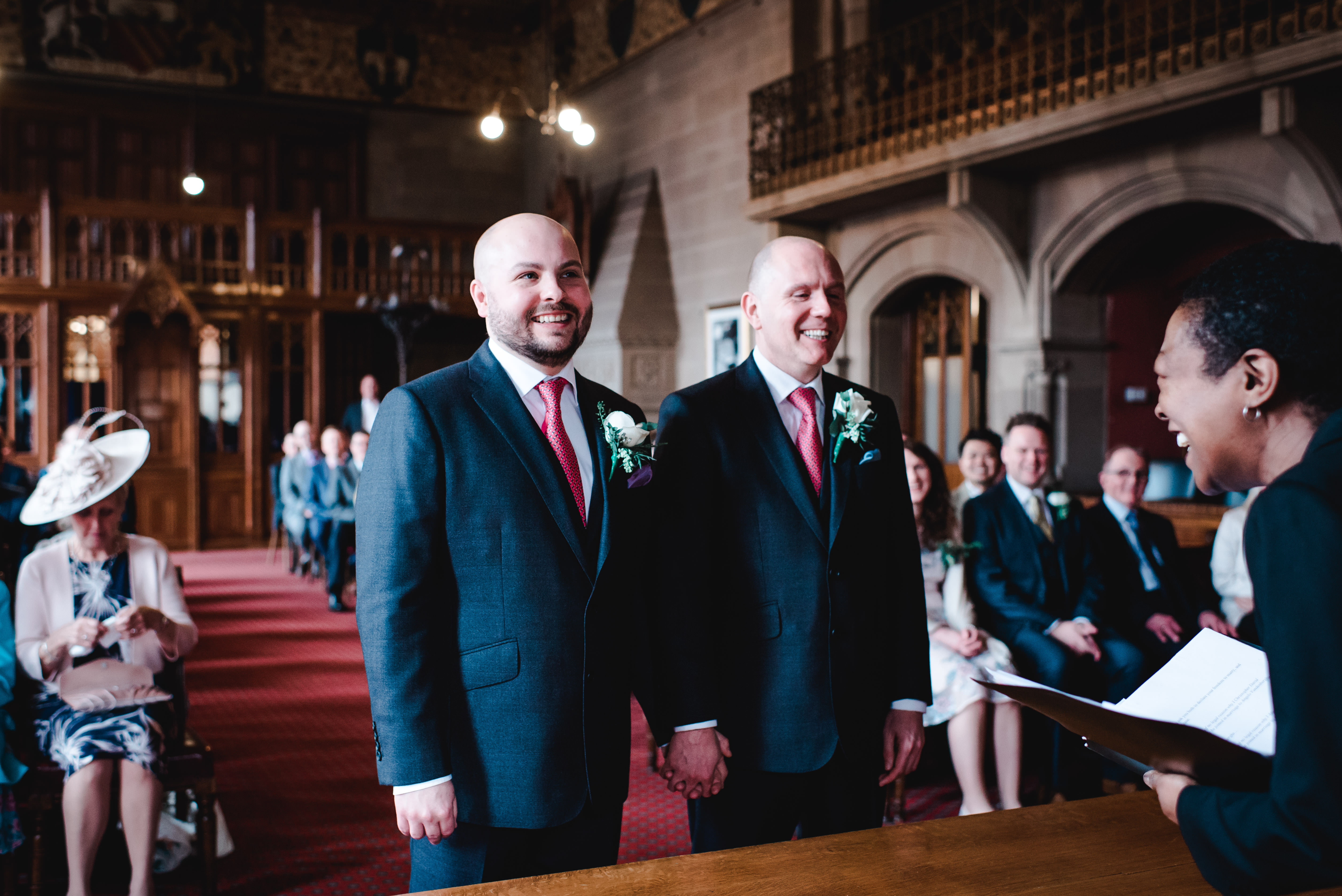 Groom and groom laughing with registrar at Manchester Town Hall