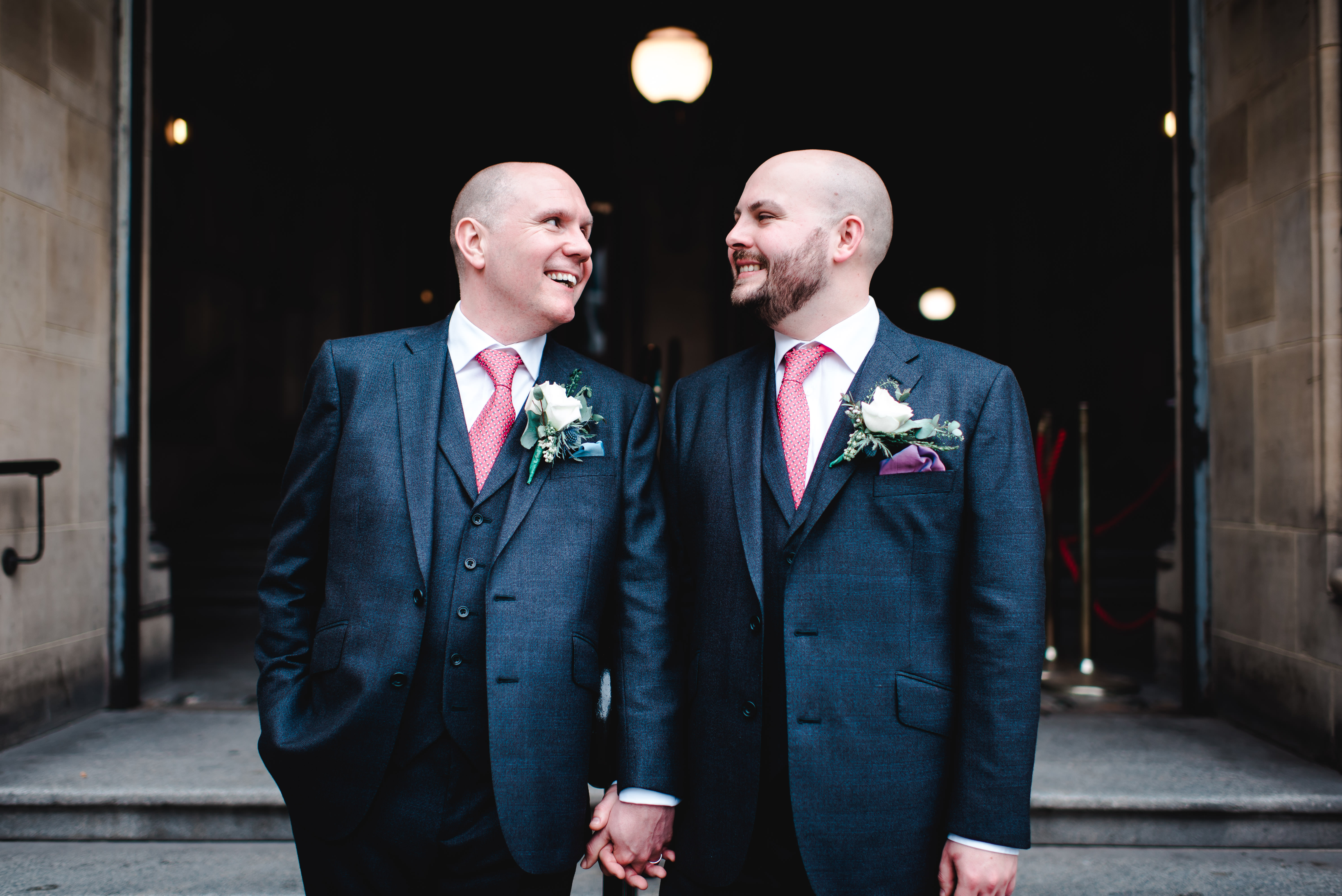 Groom and groom hand in hand in front of Manchester Town Hall steps